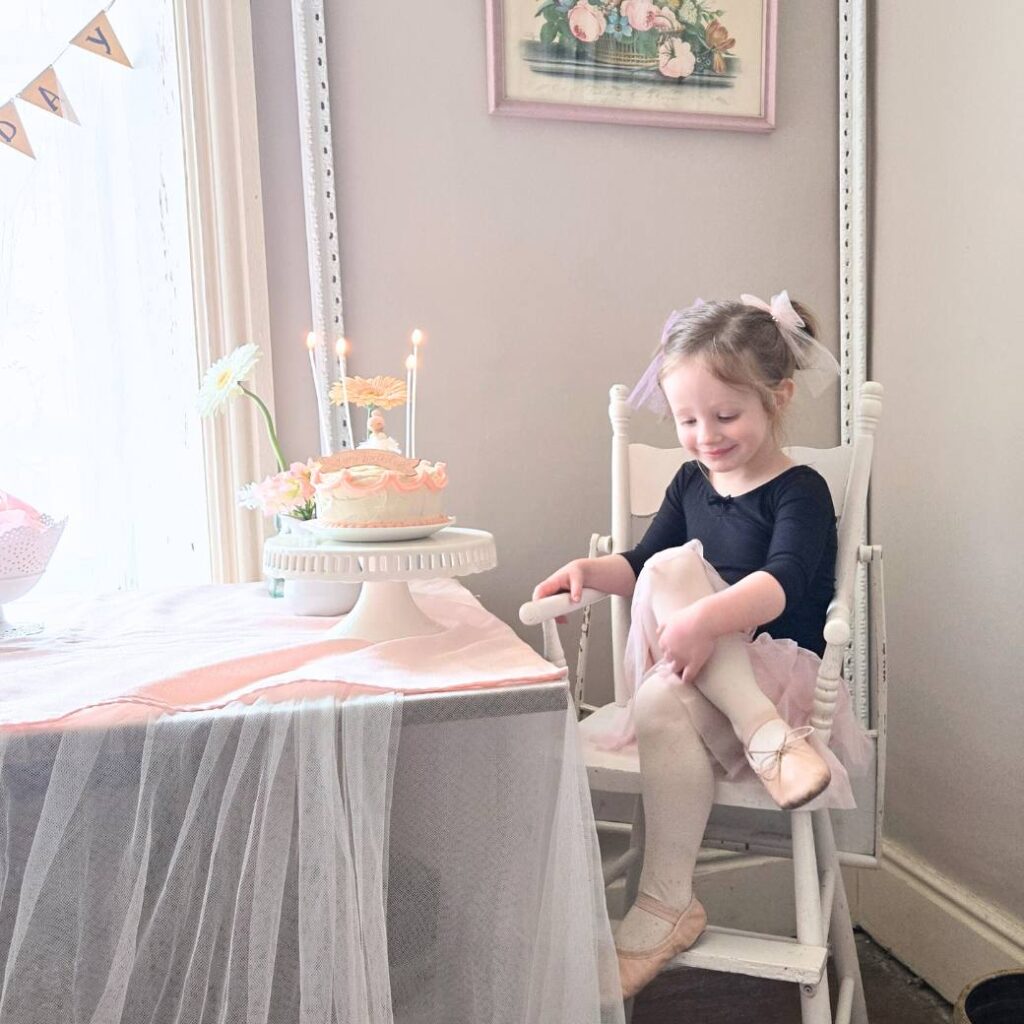 Little girl dressed like a ballerina, ready to blow out her birthday candles on her birthday cake. 