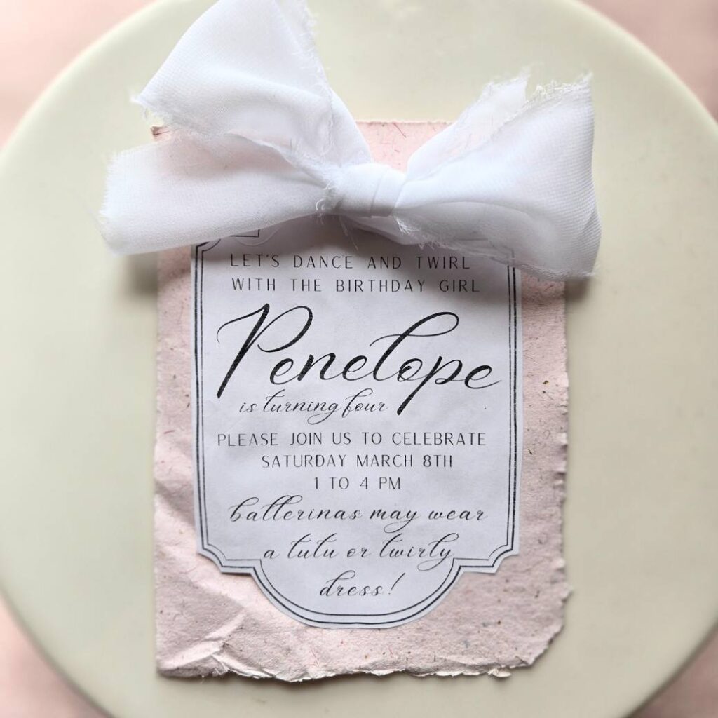 Pink birthday party invitation with big white bow.