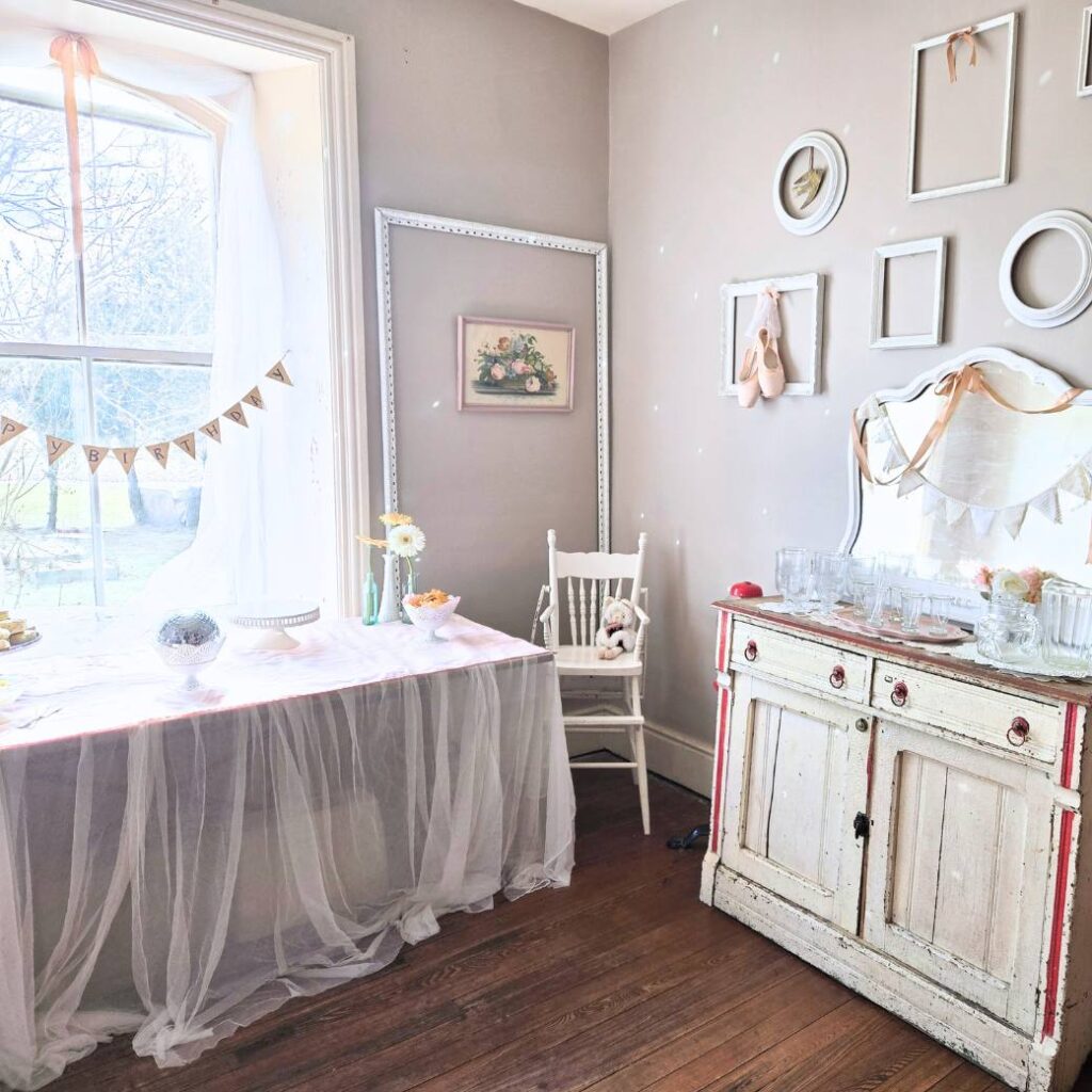 Dining room in old house decorated with white and pink party decorations.