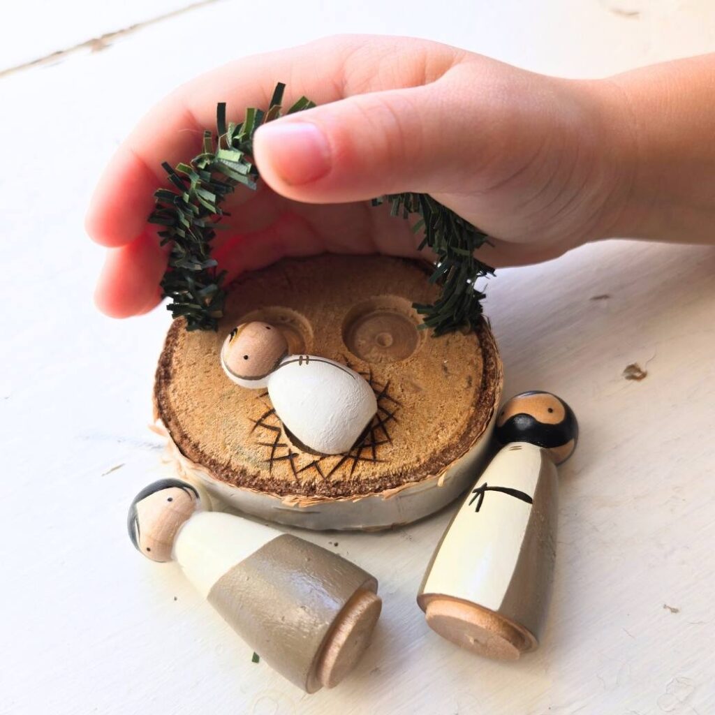 three hand painted peg dolls painted as Mary, Joseph, and Baby Jesus