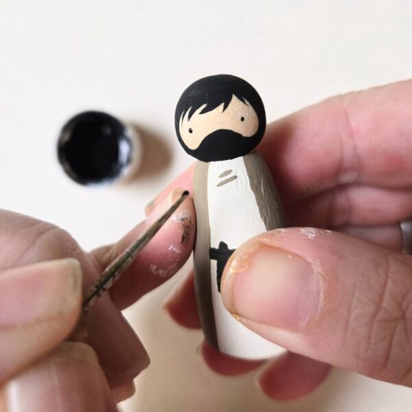 A peg doll "Joseph" being painted by hand