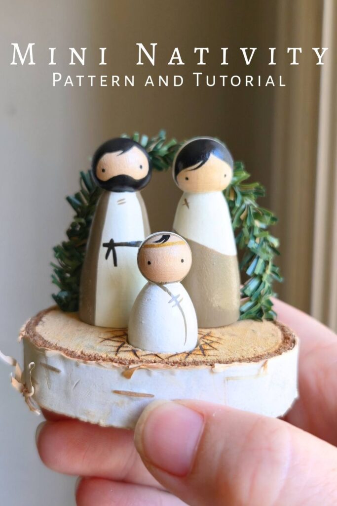 Small peg doll nativity set held in a hand.